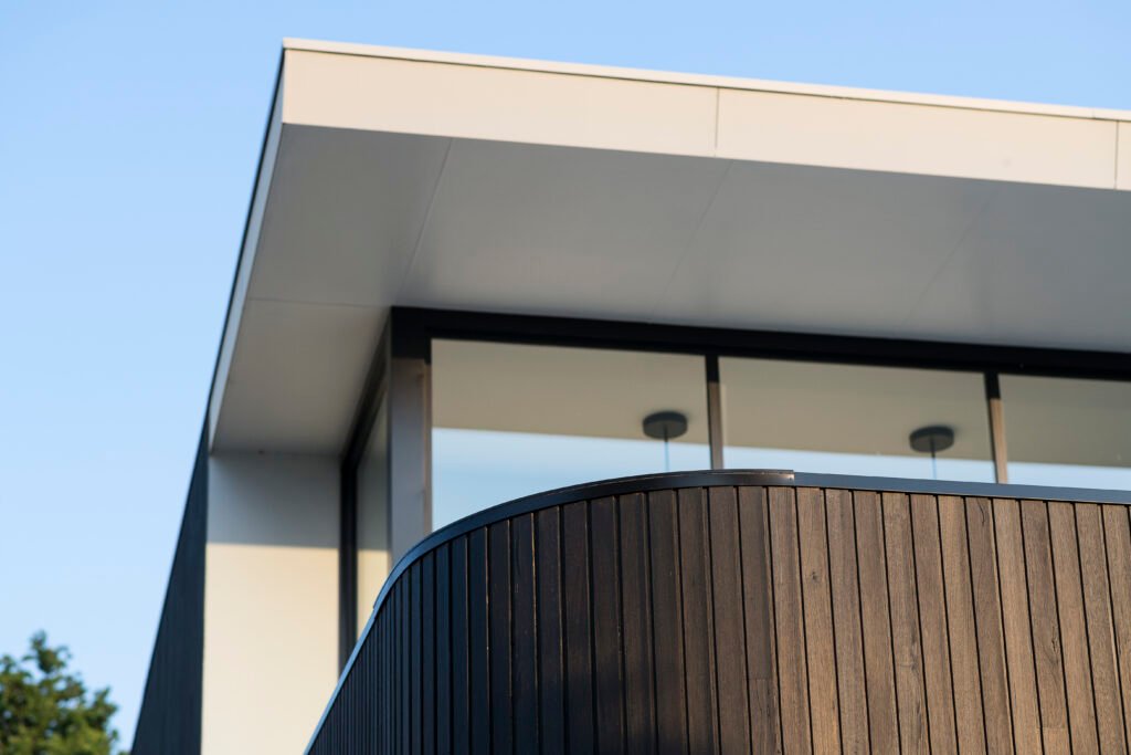 Gros plan en contre-plongée sur les détails architecturaux d'une maison moderne au style épuré.