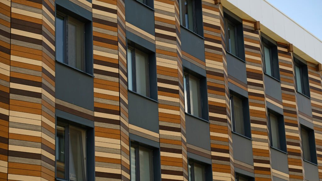 Gros plan sur le coin d'un bâtiment moderne présentant une alternance de lignes droites et de courbes.